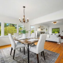 Formal dining room with original woodwork, living room in view.